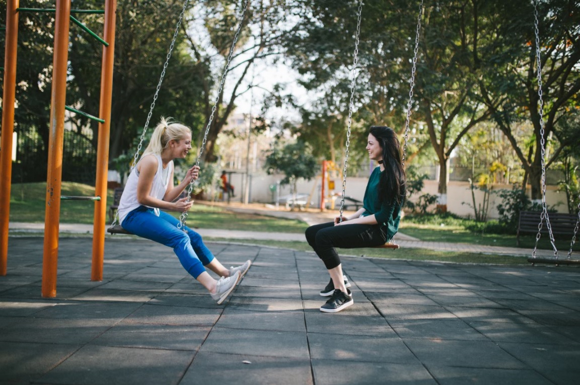 two girls on swings talking