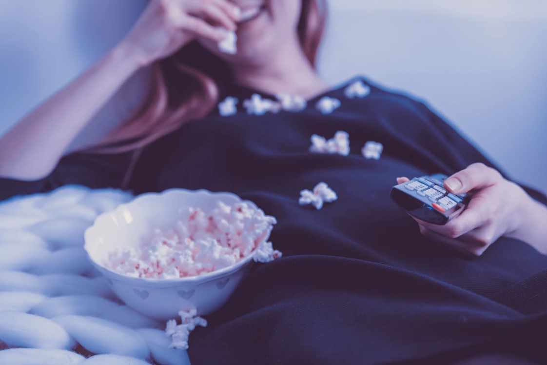woman eating popcorn while watching netflix