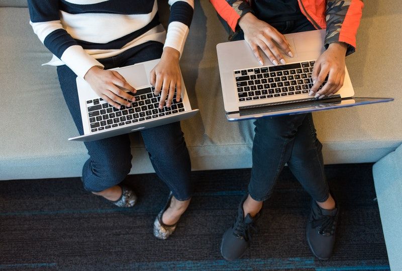two people holding laptops