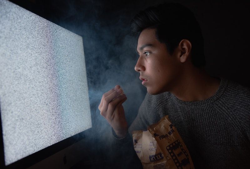 man eating chips while watching tv