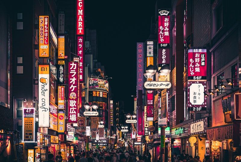 people walking past Japanese signs