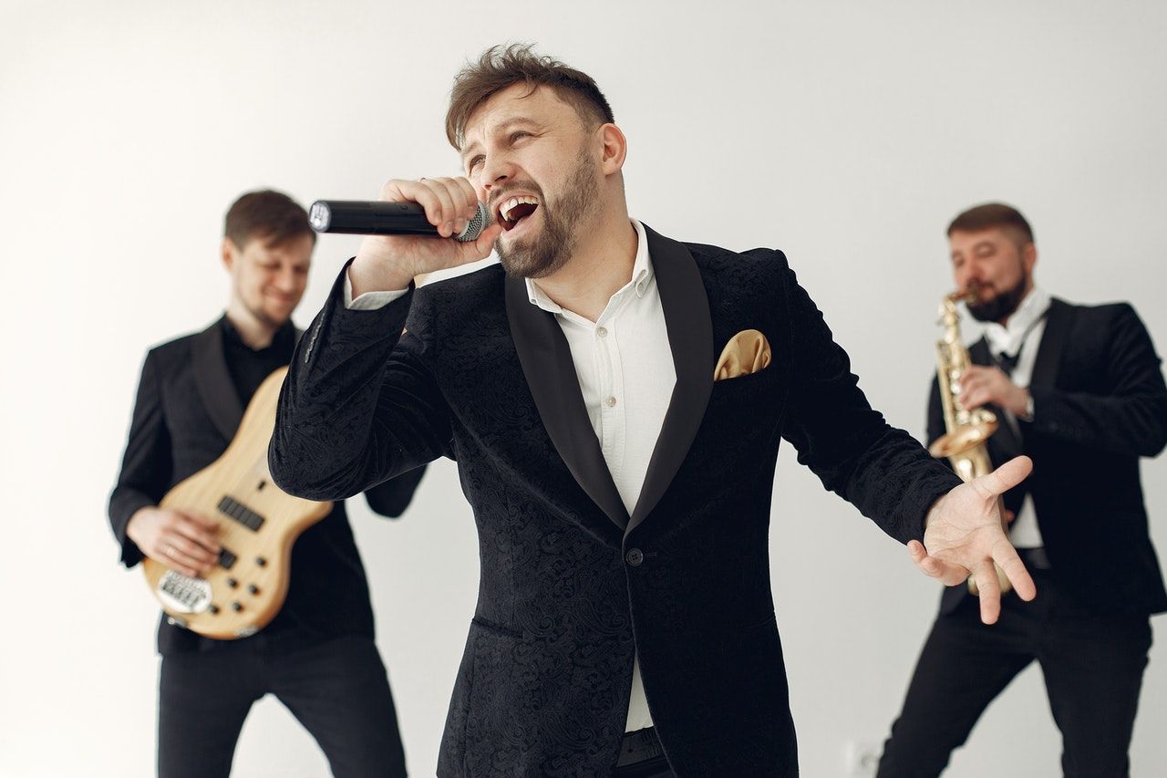man singing passionately with a band