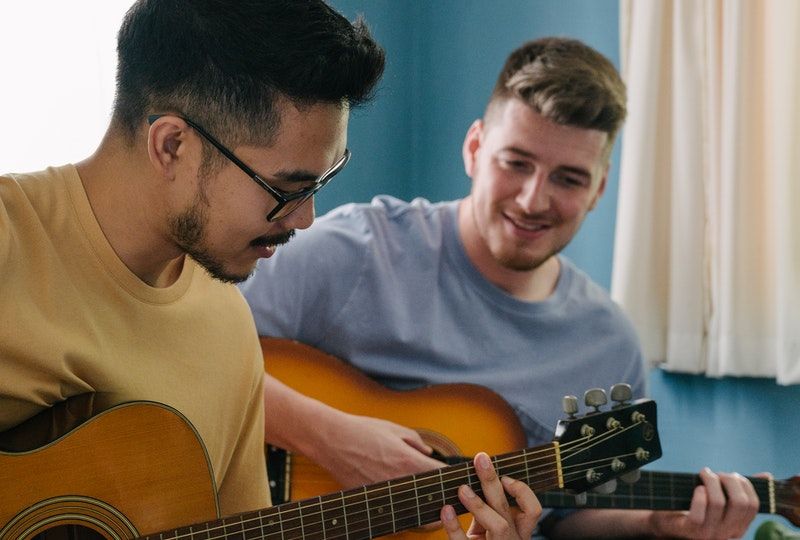 Two friends playing guitar