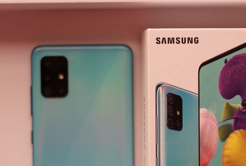 Blue phone on pink background next to Samsung box