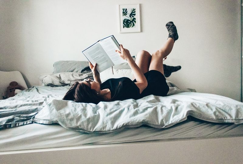 Girl reading a book in bed