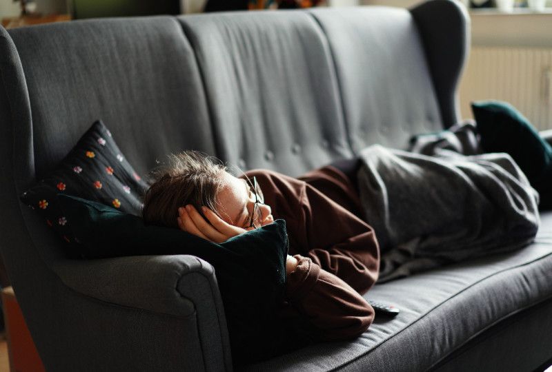 person lazily lying on couch