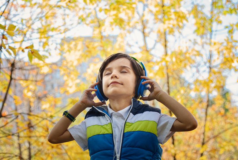 boy is listening to and immersed in music in a forest