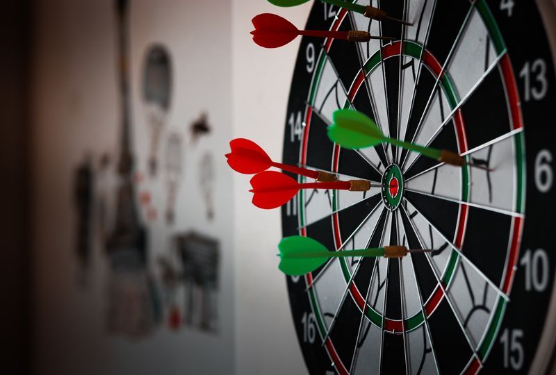 focus expressed with red and green darts on a target with one dart hitting the bullseye