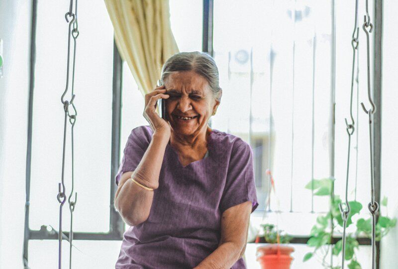 grandmother smiling and speaking on the phone