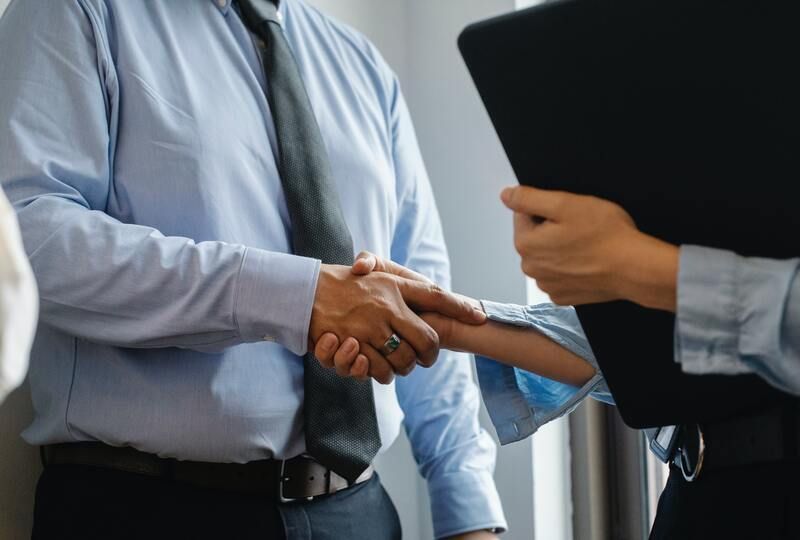 formal greeting handshake between two businesspeople