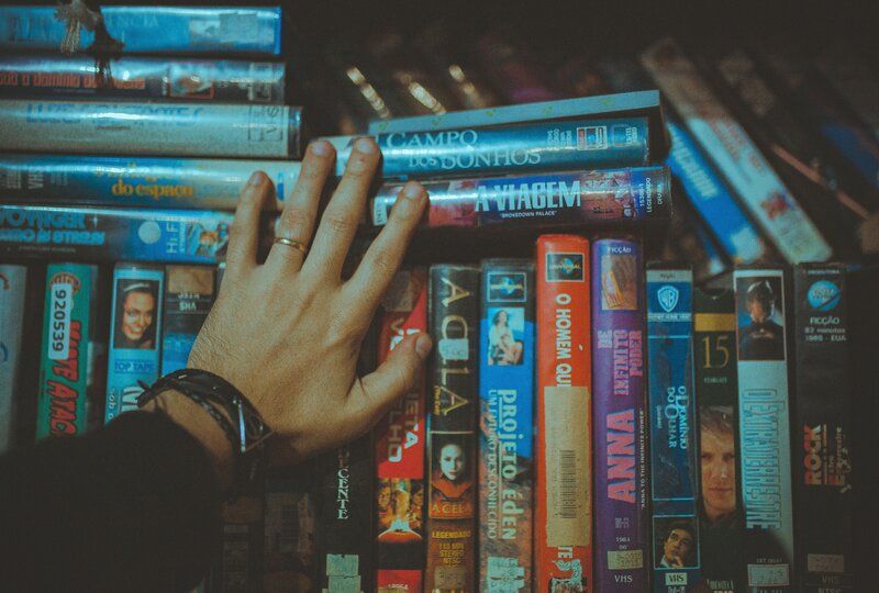 a person touching a pile of VHS tapes