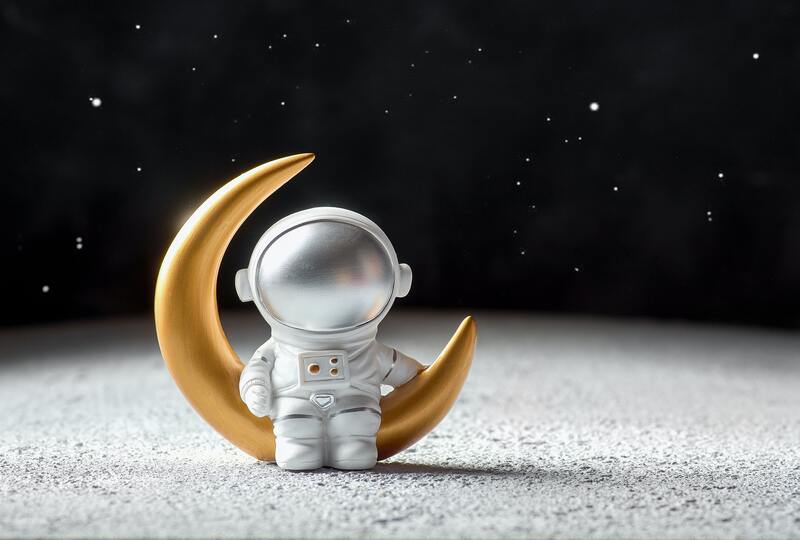 astronaut figurine with golden moon