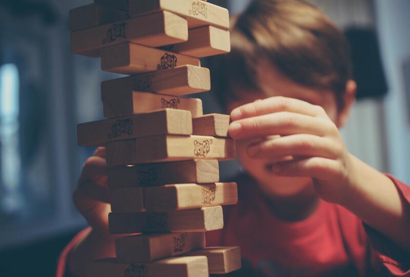 boy playing a difficult jenga game