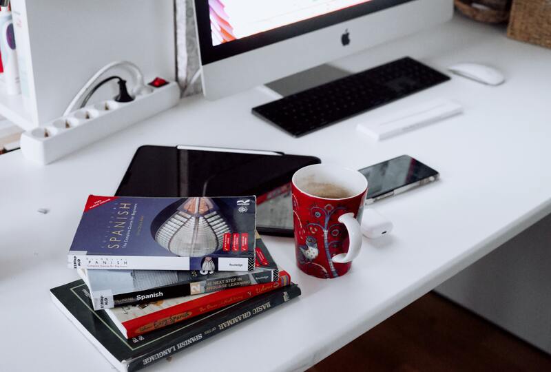 white desktop with monitor and books on the table