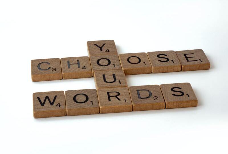 Scrabble tiles that say 'Choose your words'
