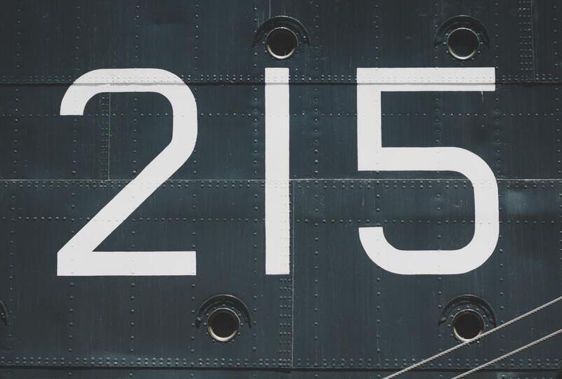 The numbers 215 printed on the side of a ship