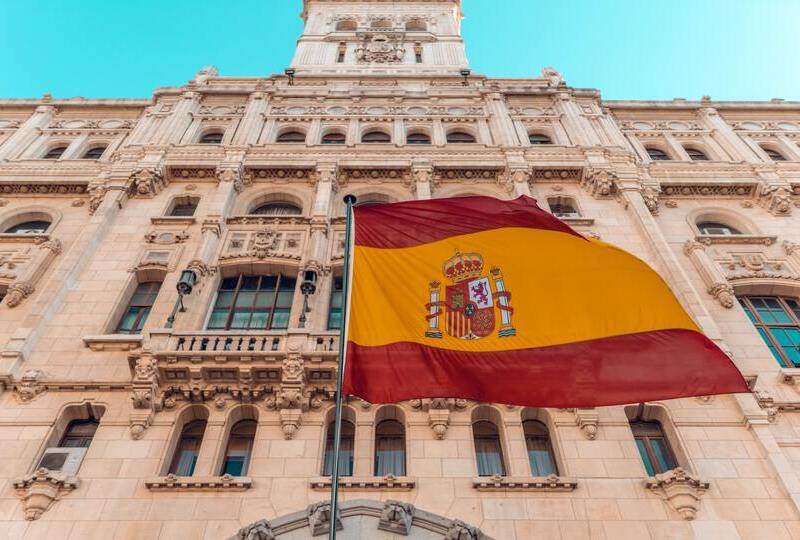 The Spanish flag with a historical building in the background