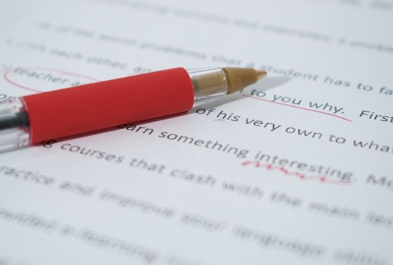 A red pen on top of a corrected essay