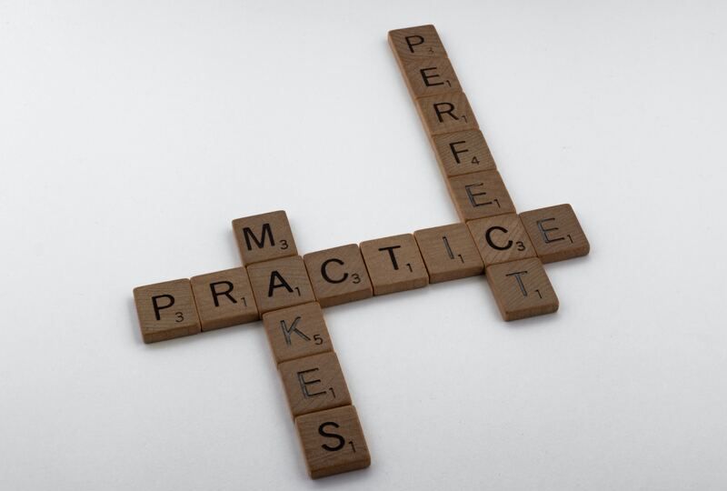 Scrabble tiles that spell out "Practice makes perfect"