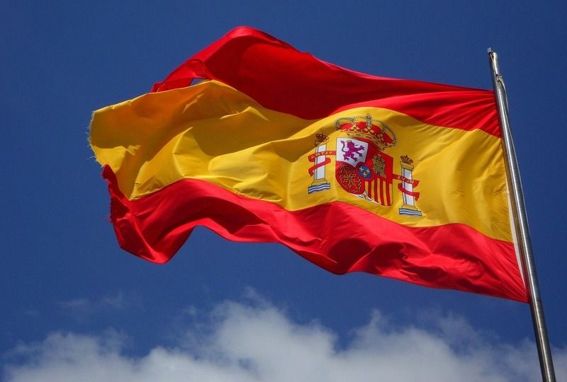 The Spanish flag waving against a blue sky