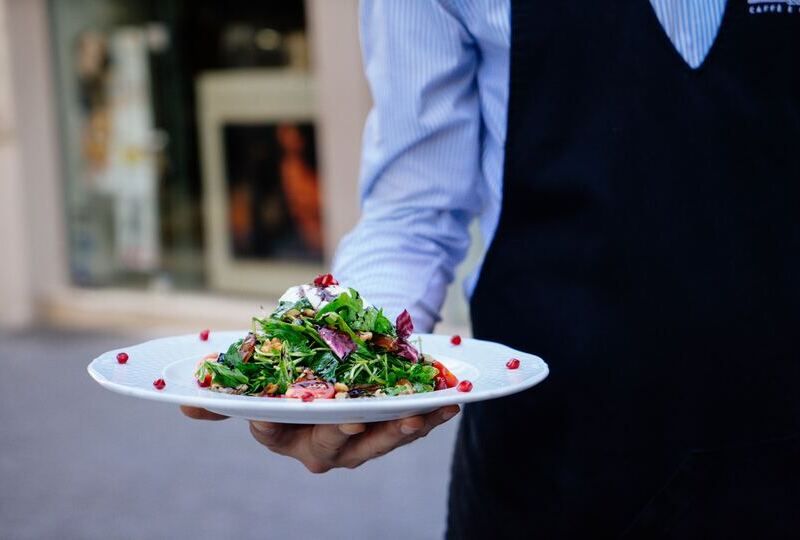 A waiter holding a salad