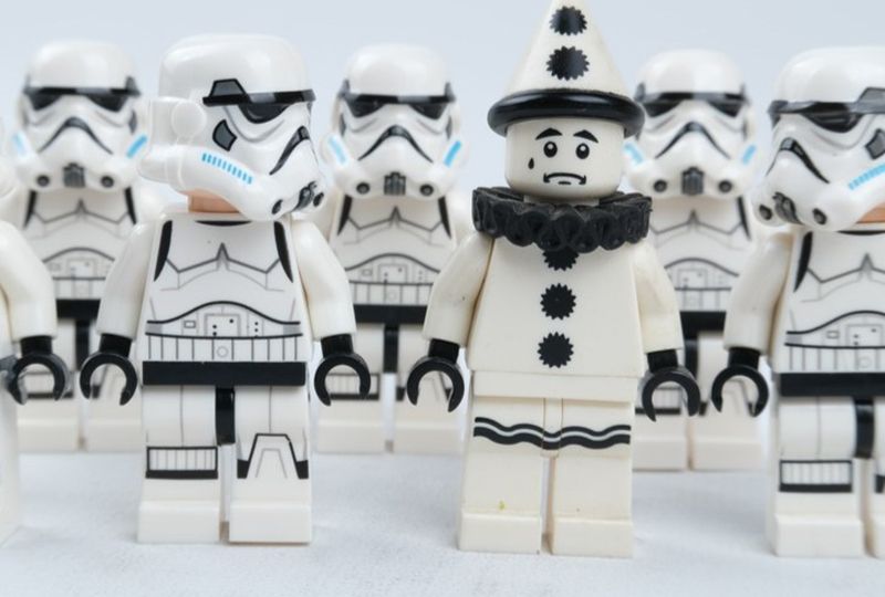 Star Wars lego fighters lined up and one dressed like a clown that doesn't belong