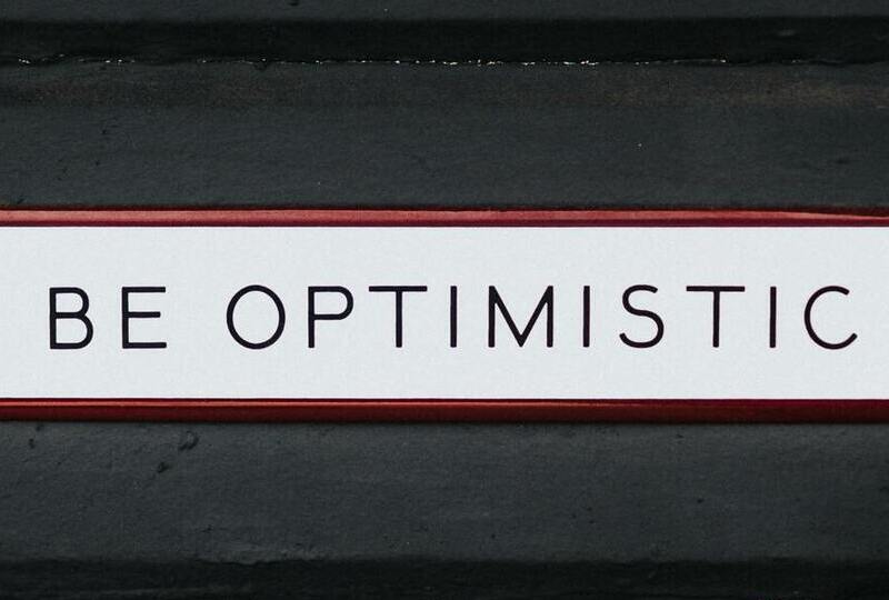 A sign that says Be Optimistic
