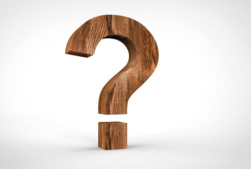 A question mark made out of wood on a white background