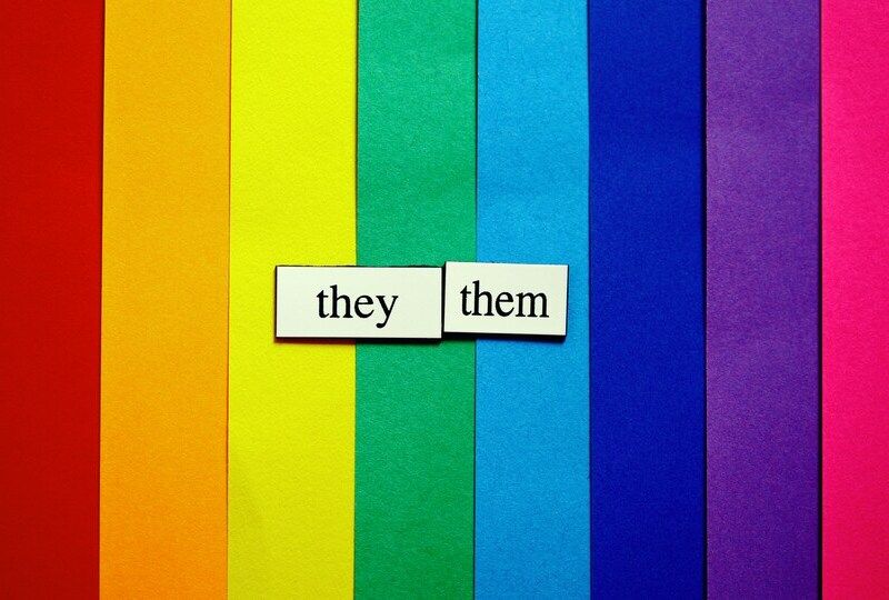 A rainbow of paper with the words 'they'/'them' on top