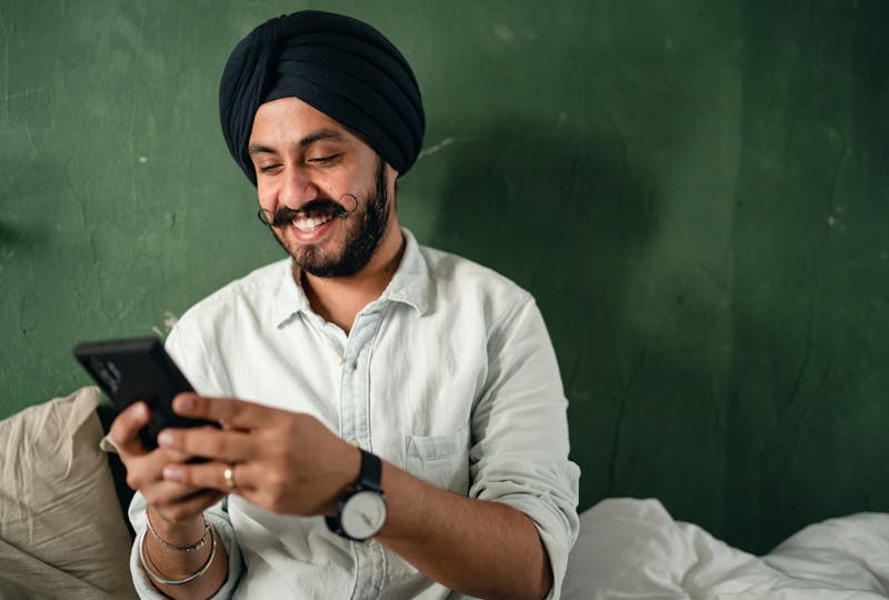 Man texting and smiling.