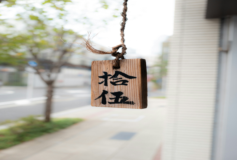a wooden sign hanging from a rope on a building