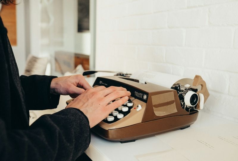 man typing on a vintage typewriter