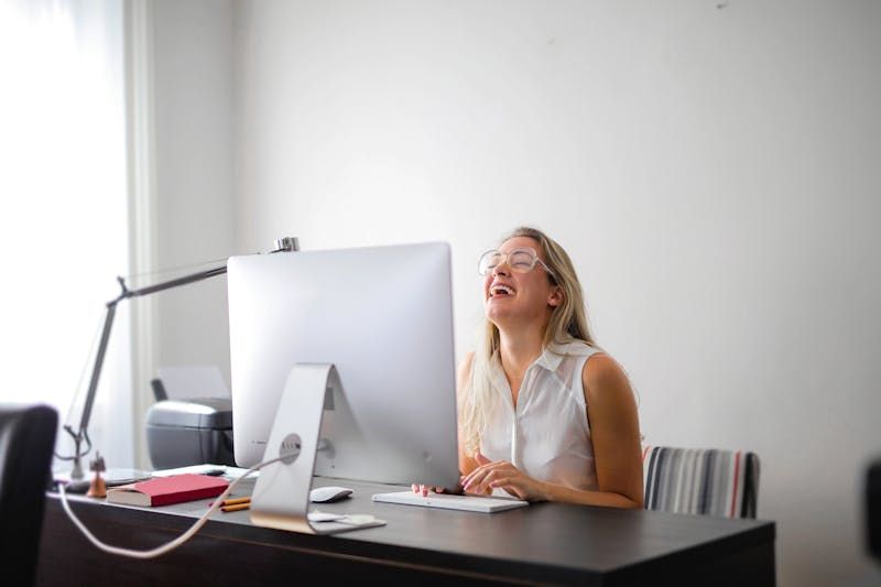 Woman laughing at her computer.