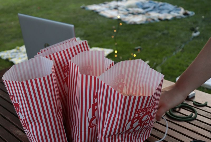 Popcorn and laptop laying on table in the field