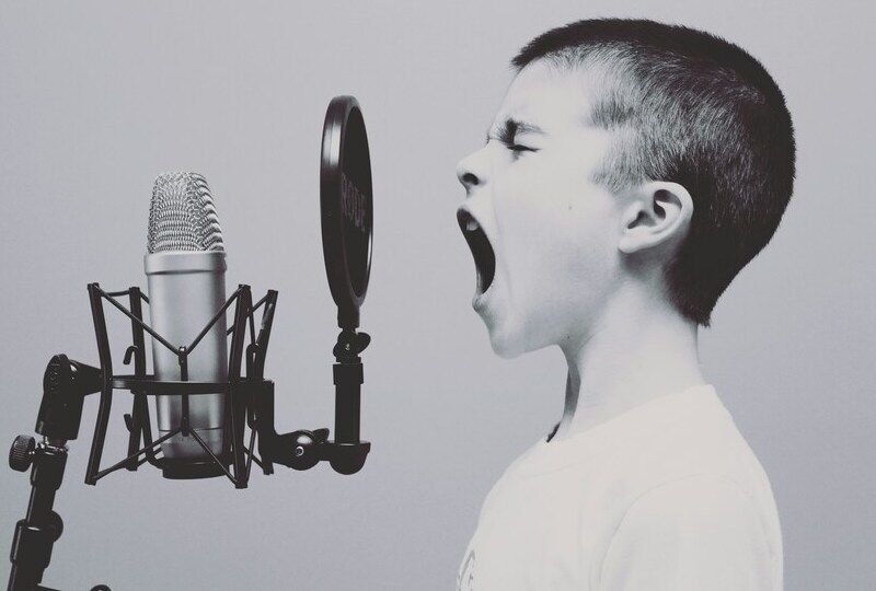 A child yelling or singing into a studio microphone