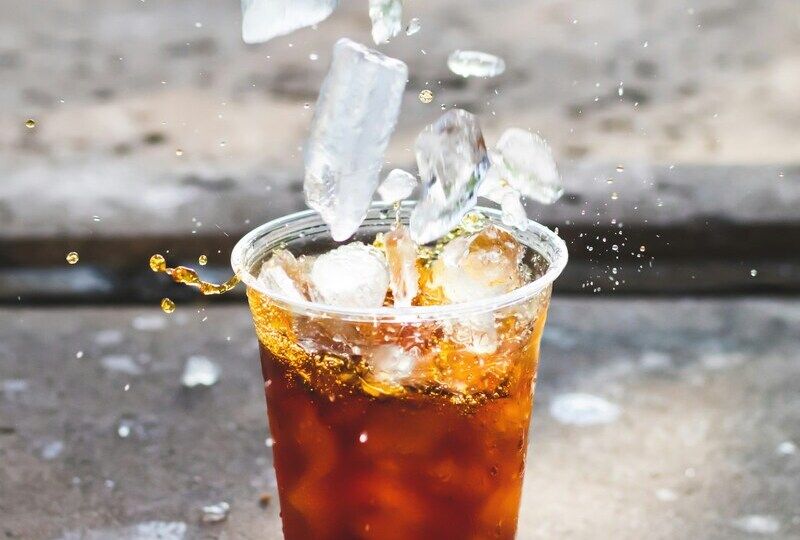 Ice splashing into a cup of cola